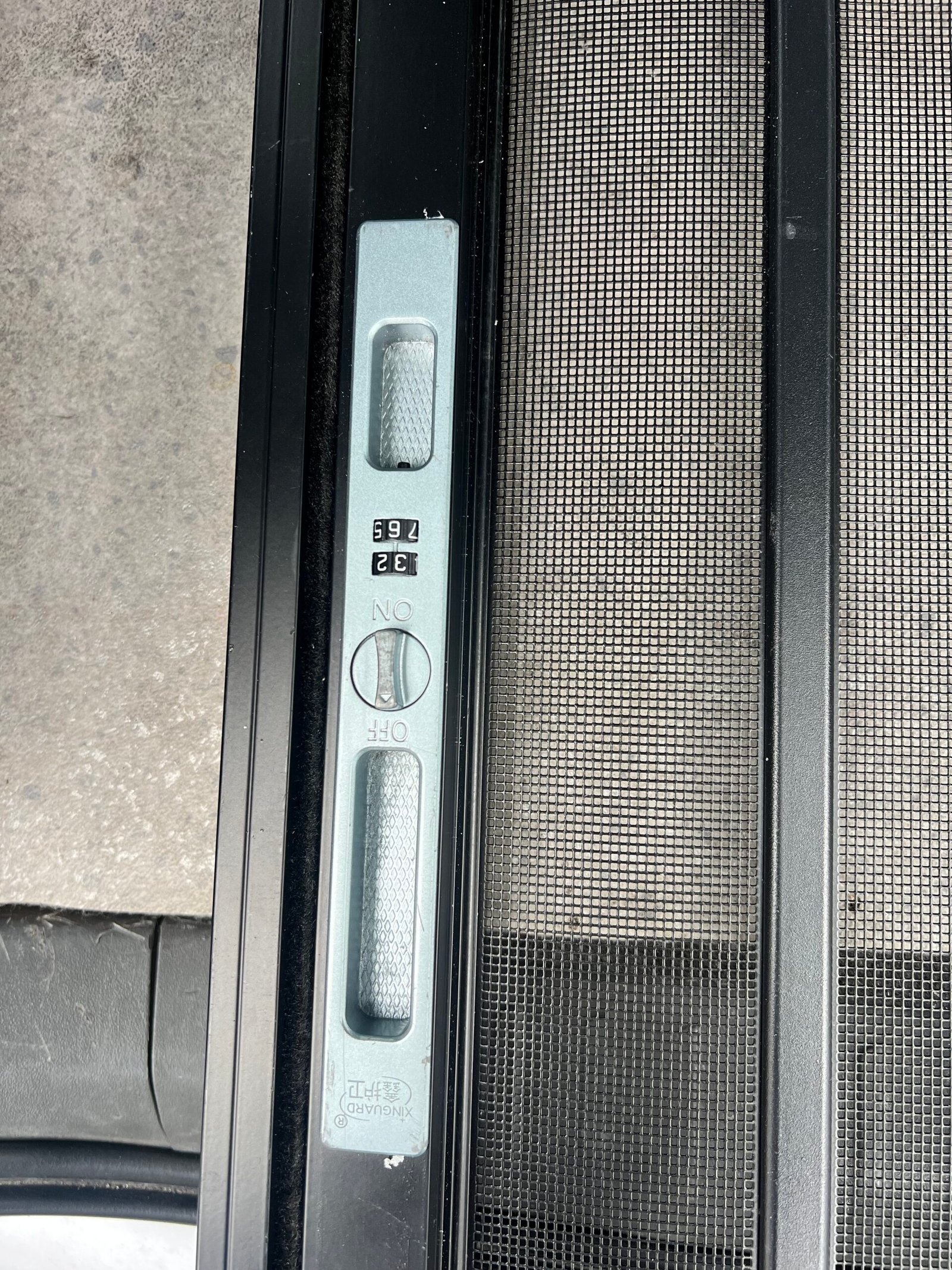 Close-up of the sliding latch mechanism on a pet screen door frame