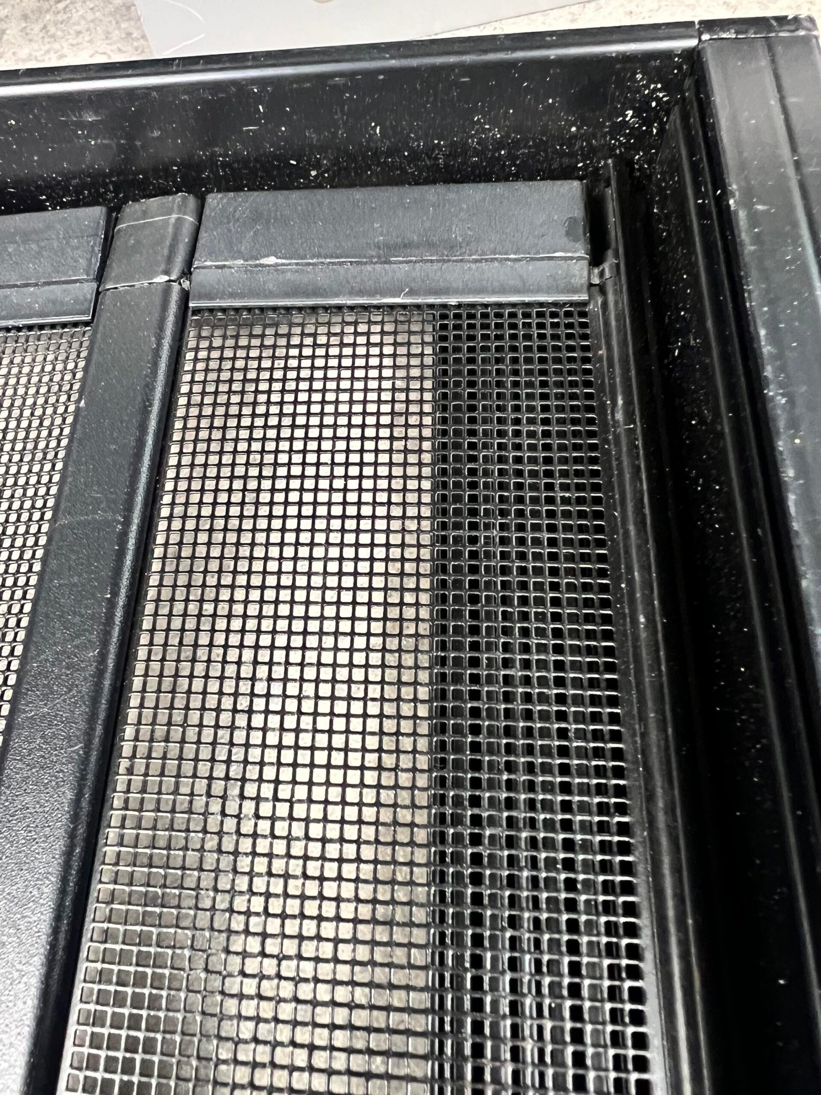 Close-up of fine pet screen mesh in a black aluminium frame