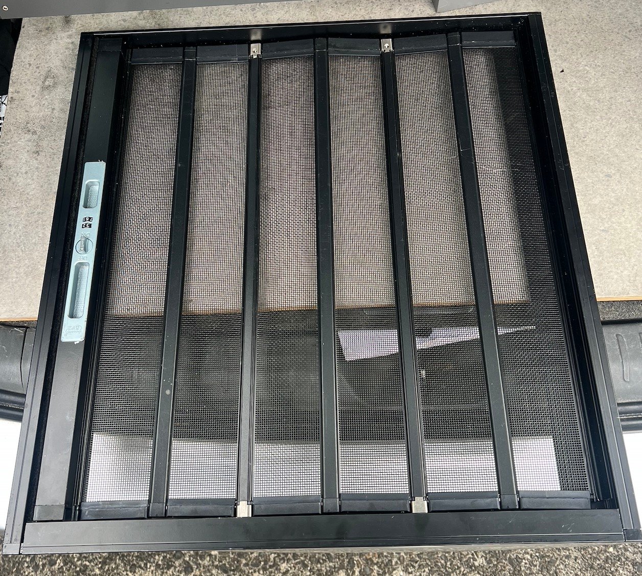 Top-down view of a folded multi-panel pet screen door frame