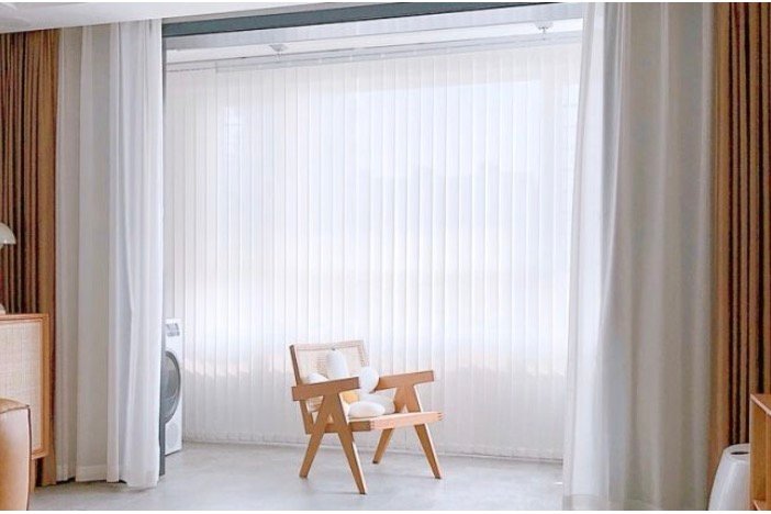 Sheer white curtains layered with warm-toned drapes in an Auckland home