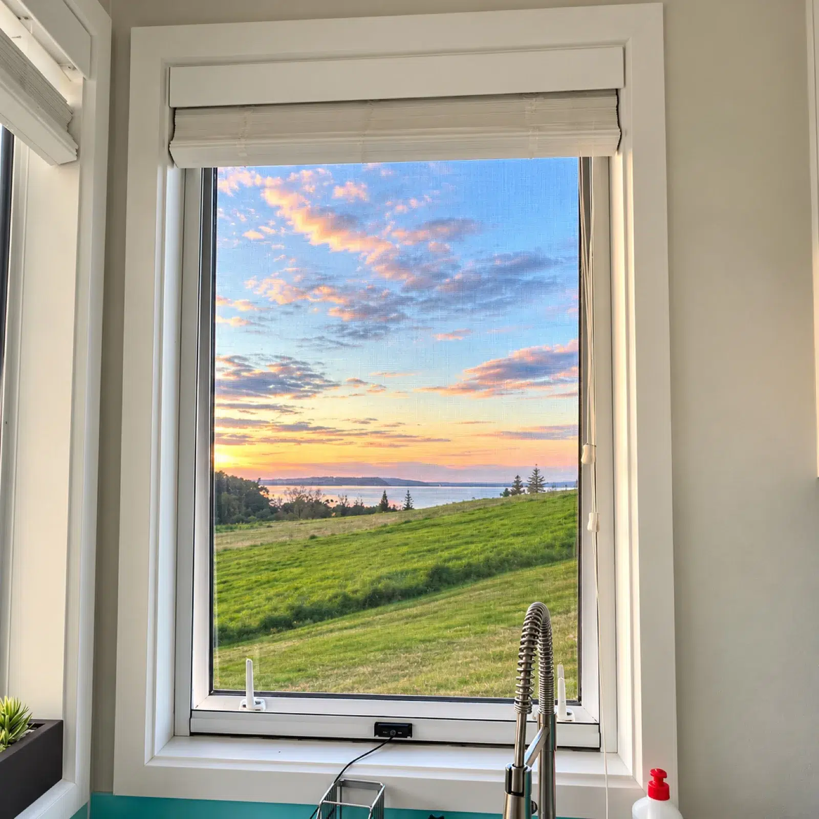 Retractable fly screen on a kitchen window at sunset