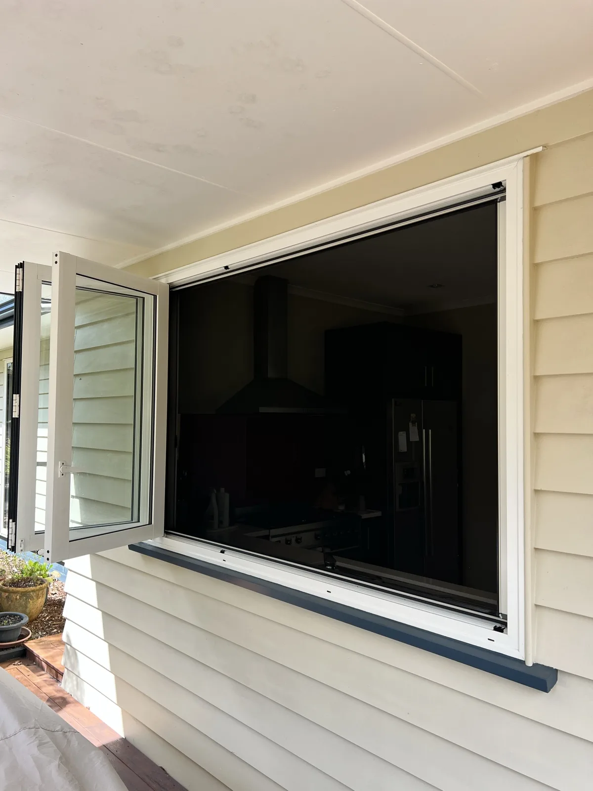 Fly screen on a weatherboard home window