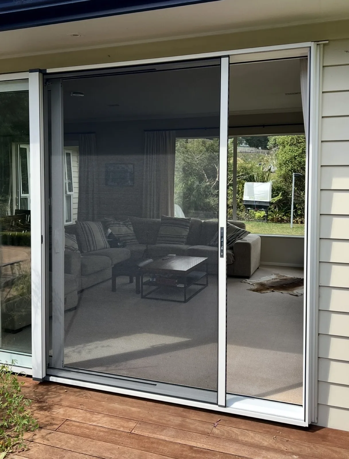 White sliding door fly screen onto a deck